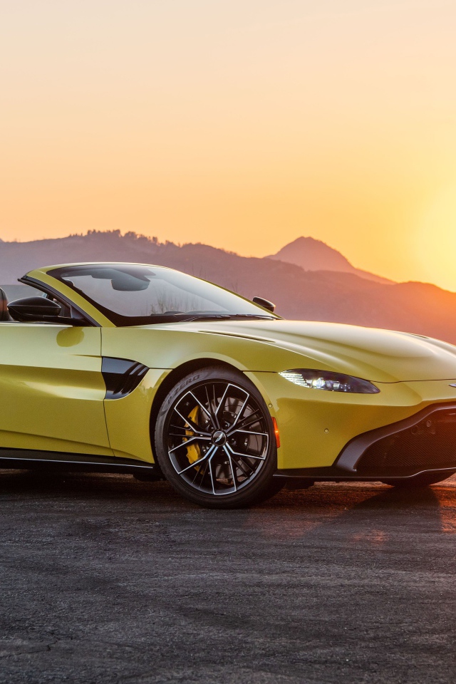 Желтый автомобиль  Aston Martin Vantage Roadster, 2021 года на закате