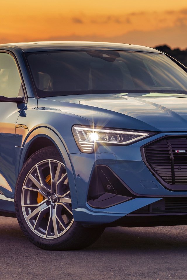 Синий автомобиль Audi E-Tron 55 Quattro S Line 2020 года на закате