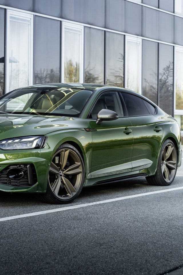 Зеленый автомобиль Audi RS 5 Sportback 2020 года у здания 