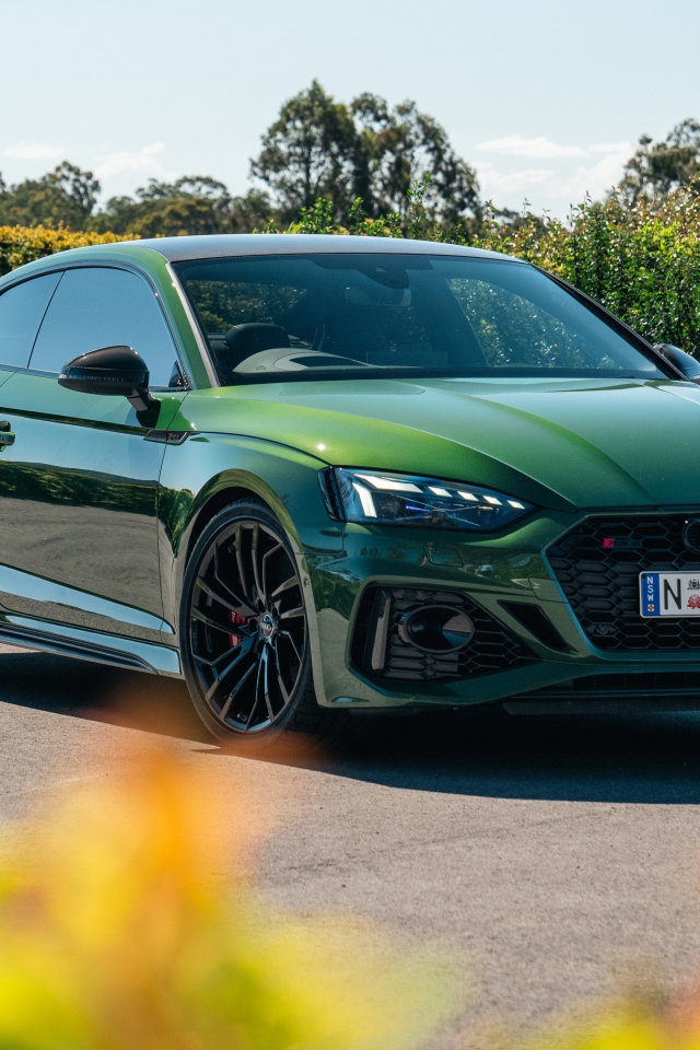 Зеленый автомобиль Audi RS 5 Coupé 2020  года в лучах солнца