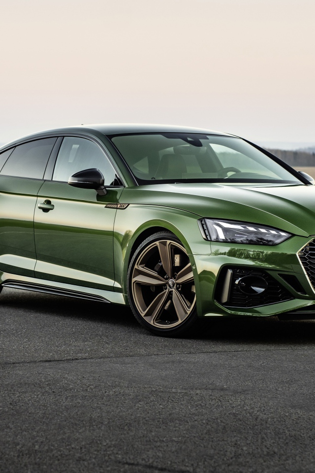 Зеленый автомобиль Audi RS 5 Sportback 2020 года на фоне поля