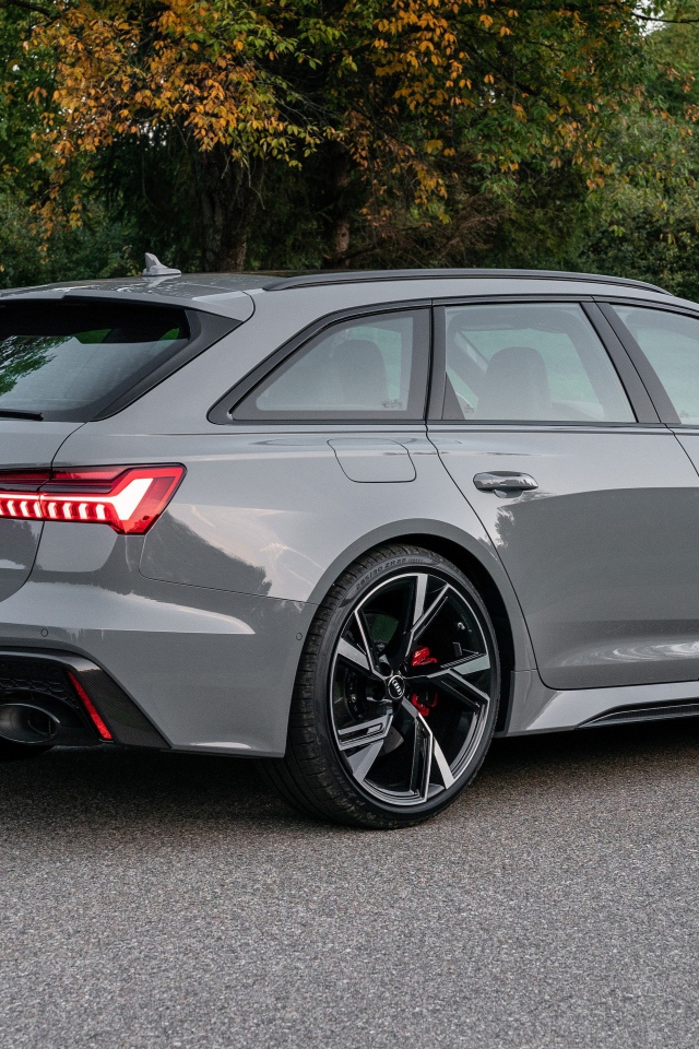 Серебристый автомобиль Audi RS 6 Avant, 2021 года вид сзади