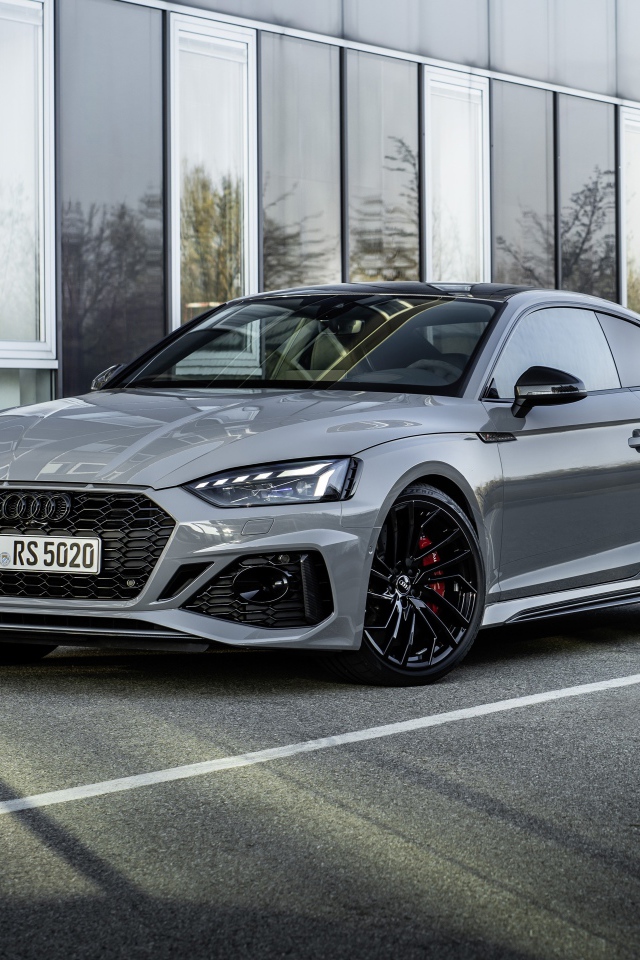 Серебристый автомобиль Audi RS 5 Coupe у здания 