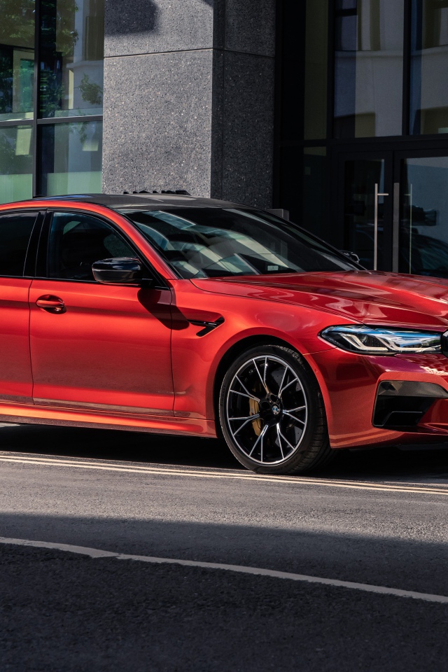 Красный автомобиль BMW M5 Competition 2020 года у дома