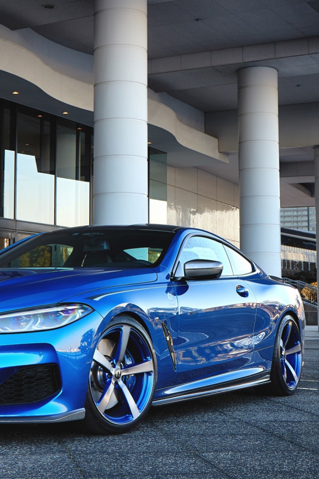 Синий автомобиль BMW M850i XDrive Coupe 2020 года у здания 