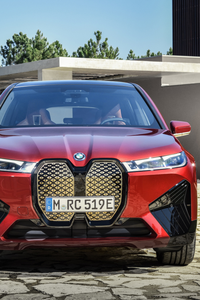 Красный автомобиль BMW IX 2021 года у дома