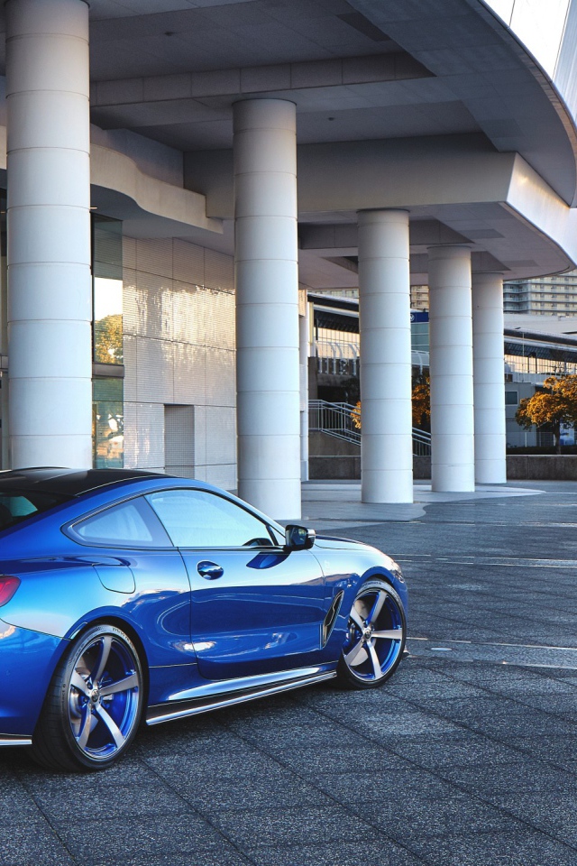 Синий автомобиль BMW M850i XDrive Coupe 2020 года у здания вид сзади