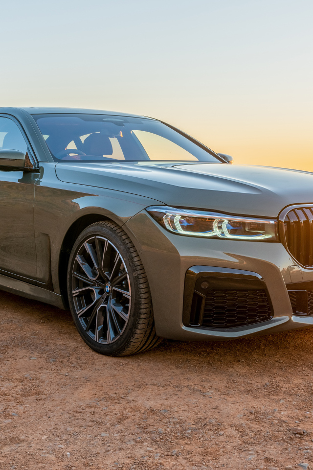 Стильный дорогой автомобиль BMW 745Le , 2020 года на фоне заката