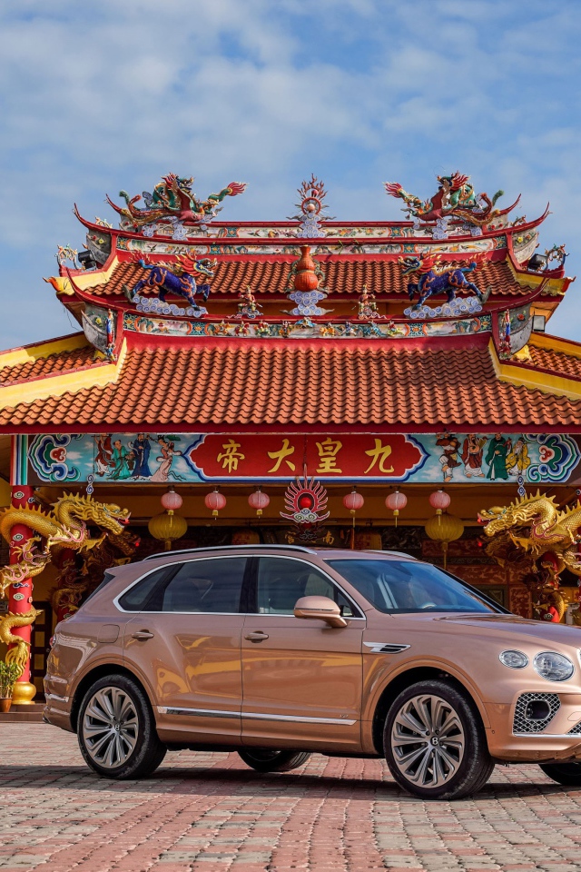 Коричневый автомобиль Bentley Bentayga V8 2020 года на фоне красивого здания