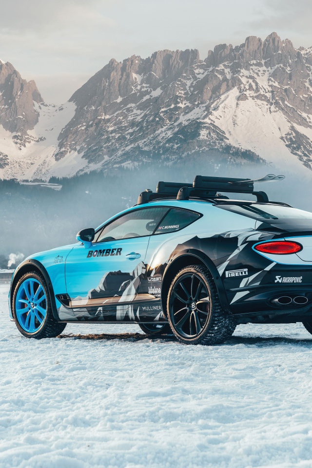 Автомобиль bentley continental gt, 2020 года на фоне заснеженных гор 