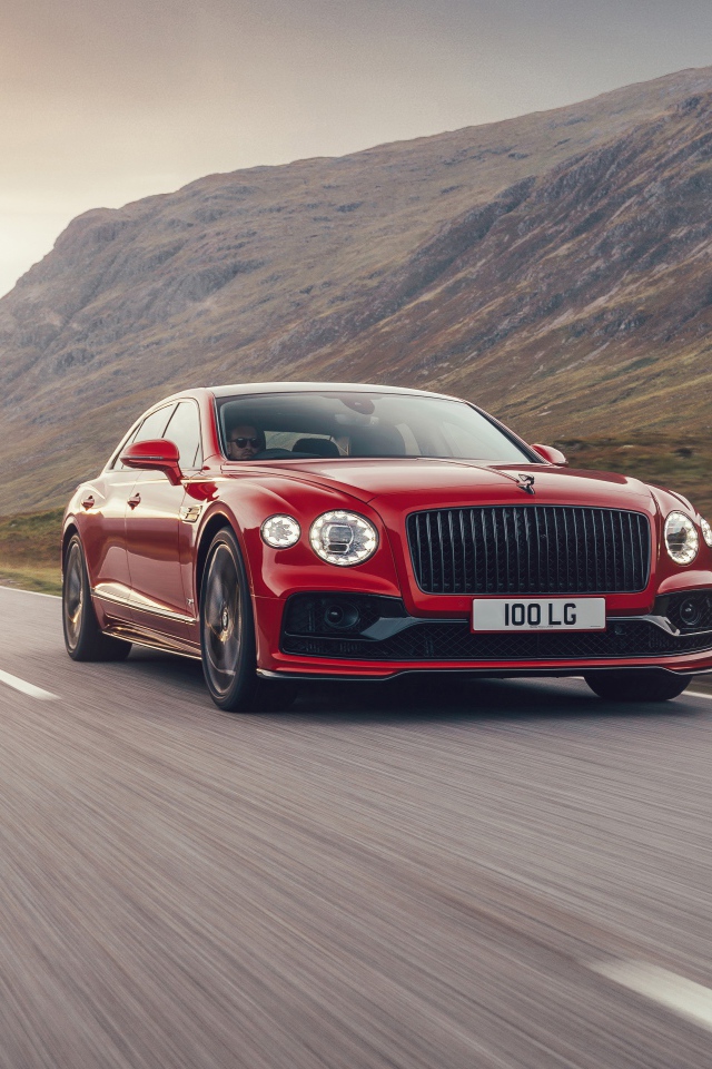 Красный автомобиль Bentley Flying Spur V8 2020 года на дороге  
