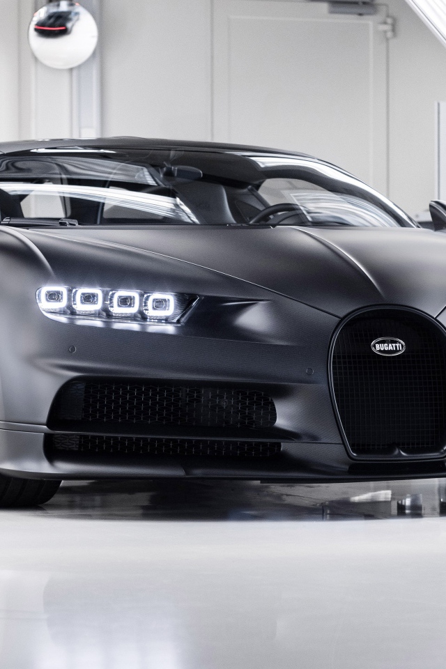 Автомобиль bugatti chiron 2020 года с включенными фарами