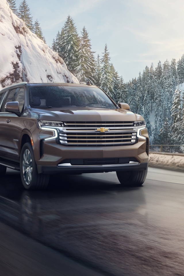 Внедорожник Chevrolet Suburban на фоне заснеженного леса, 2021 года