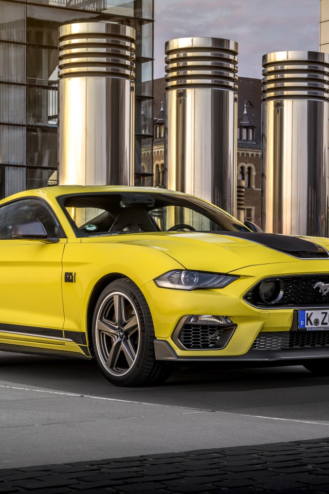 Быстрый желтый автомобиль Ford Mustang Mach 1 2021 года у здания 