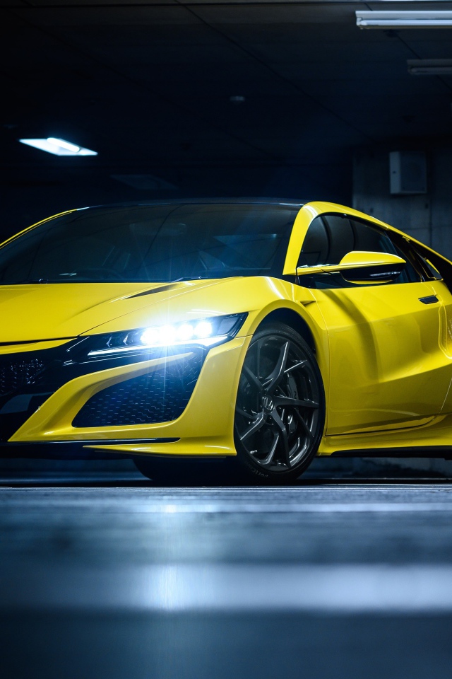 Желтый автомобиль Honda NSX с включенными фарами 