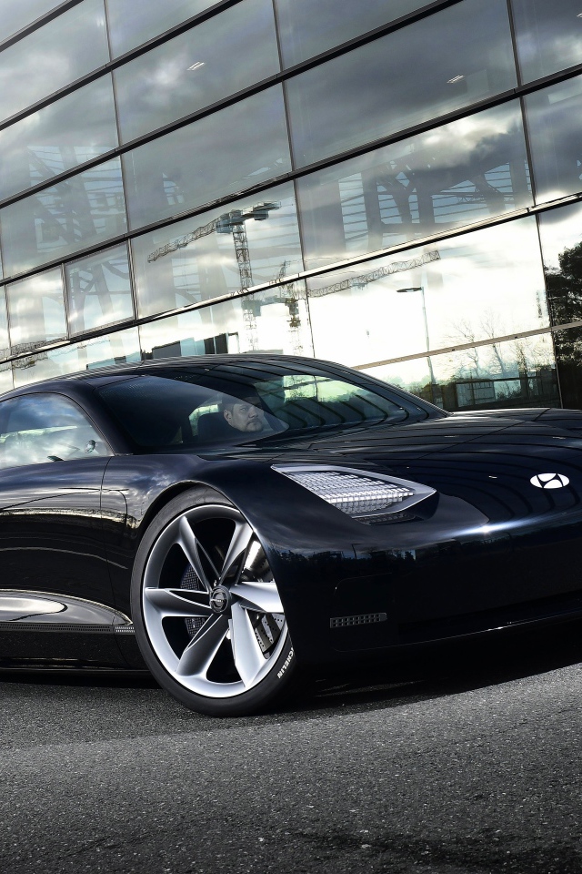 Черный автомобиль Hyundai Prophecy 2020 года у стеклянного здания 