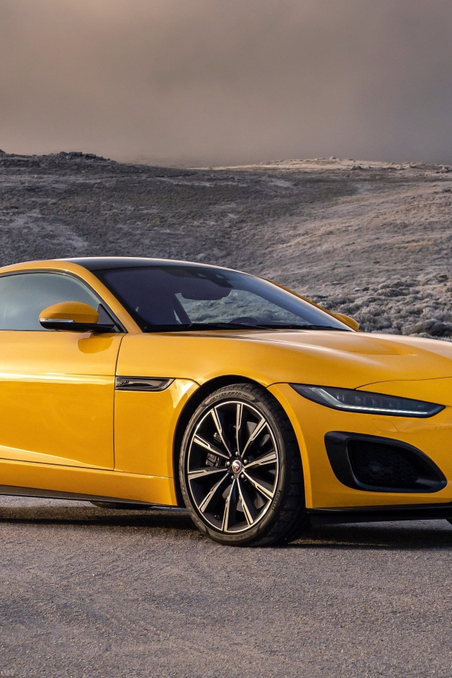 Желтый автомобиль Jaguar F-Type R Coupe 2020 года на фоне холмов