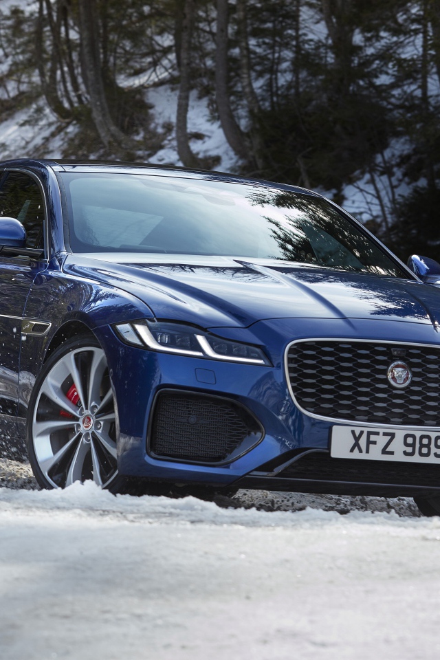 Синий Jaguar XF P300 AWD R-Dynamic 2020 года в заснеженном лесу 