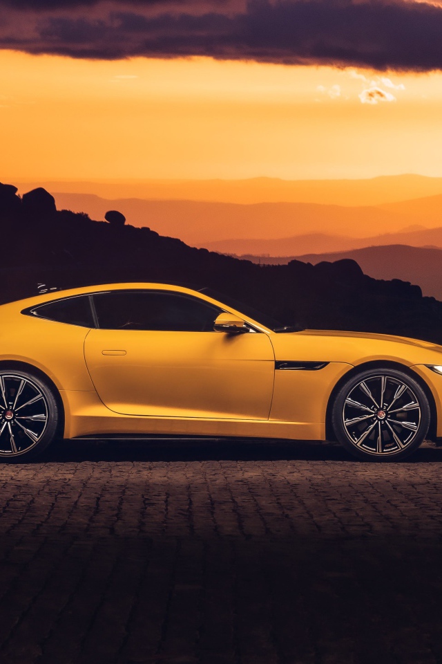 Желтый автомобиль jaguar f type 2020 года на закате 