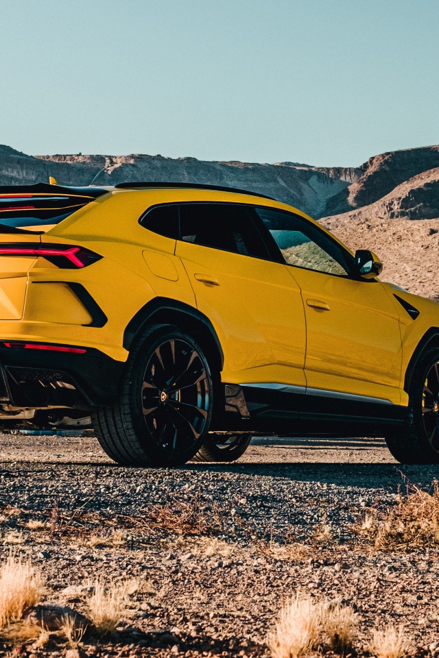 Желтый автомобиль Lamborghini Urus 2019 года в горах 