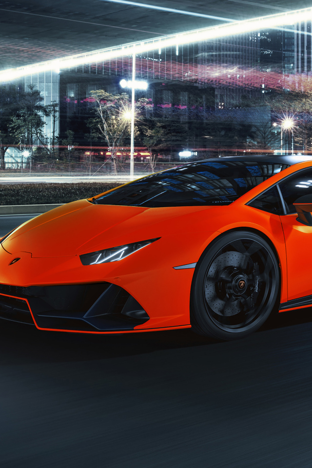 Оранжевый автомобиль Lamborghini Huracán EVO 2021 года на фоне города
