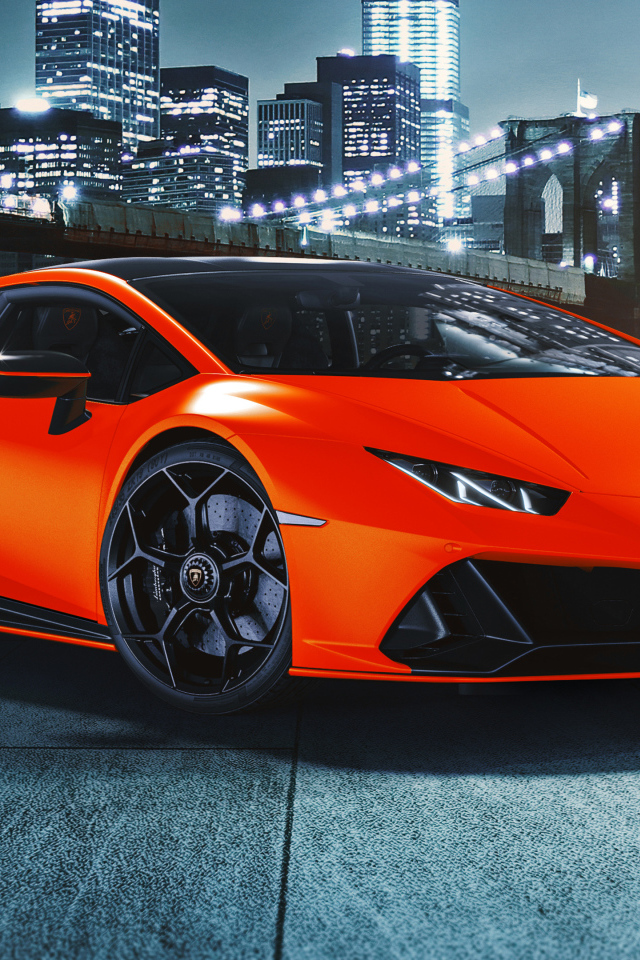 Оранжевый автомобиль Lamborghini Huracán EVO 2021 года на фоне небоскребов