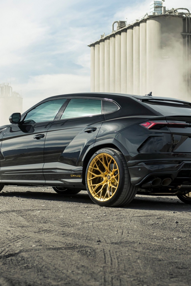 Черный внедорожник  Lamborghini Urus 2020 года на фоне завода вид сзади