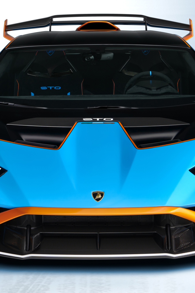 Голубой автомобиль Lamborghini Huracán STO 2021 года вид спереди на сером фоне