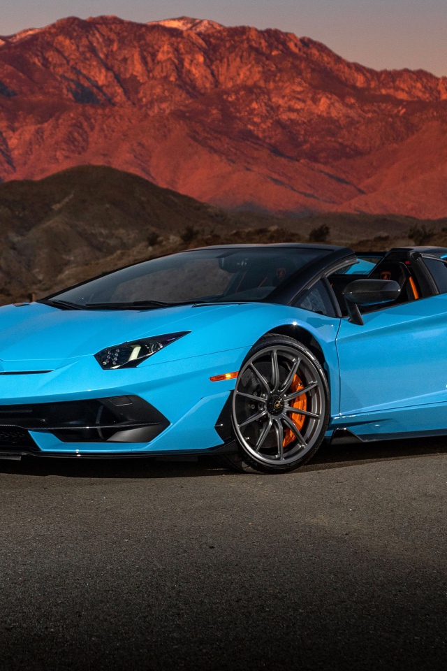 Голубой спортивный автомобиль Lamborghini Aventador SVJ Roadster, 2020 года на фоне гор