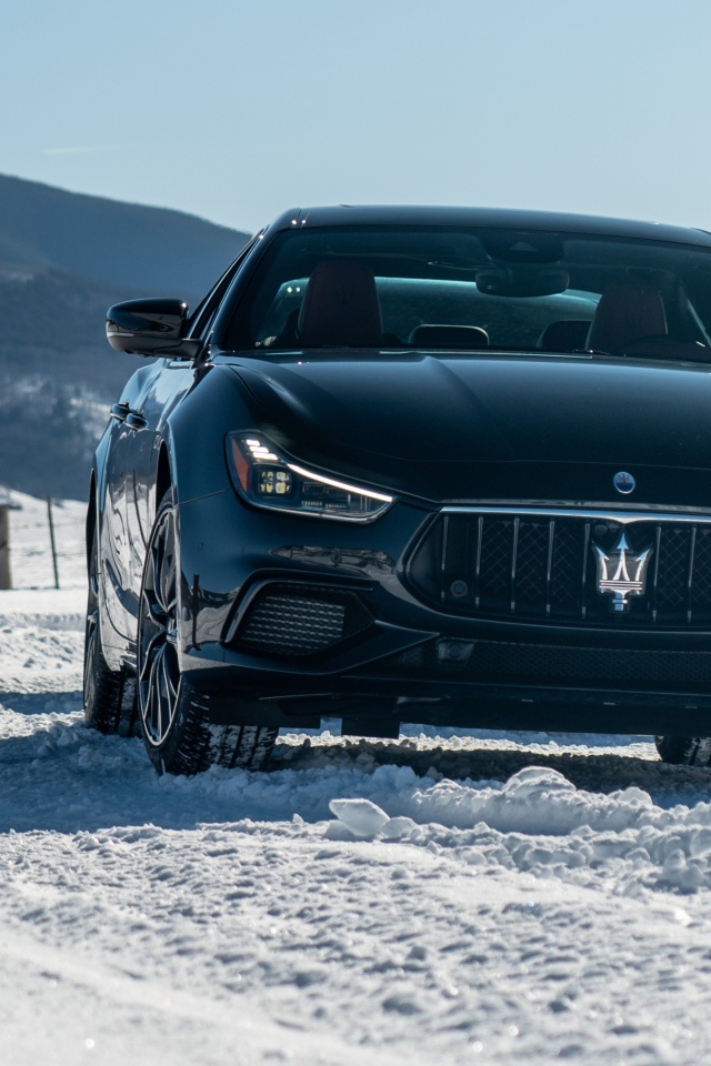 Черный автомобиль Maserati Ghibli S Q4, 2020 года едет по заснеженной дороге