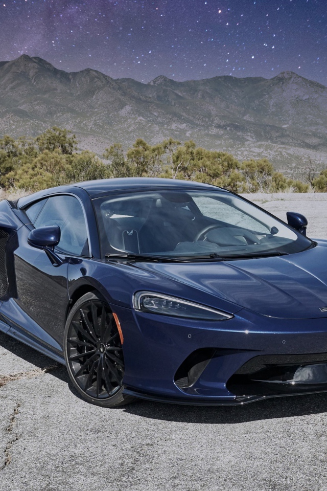 Черный автомобиль  McLaren GT, 2020 года под звездным небом