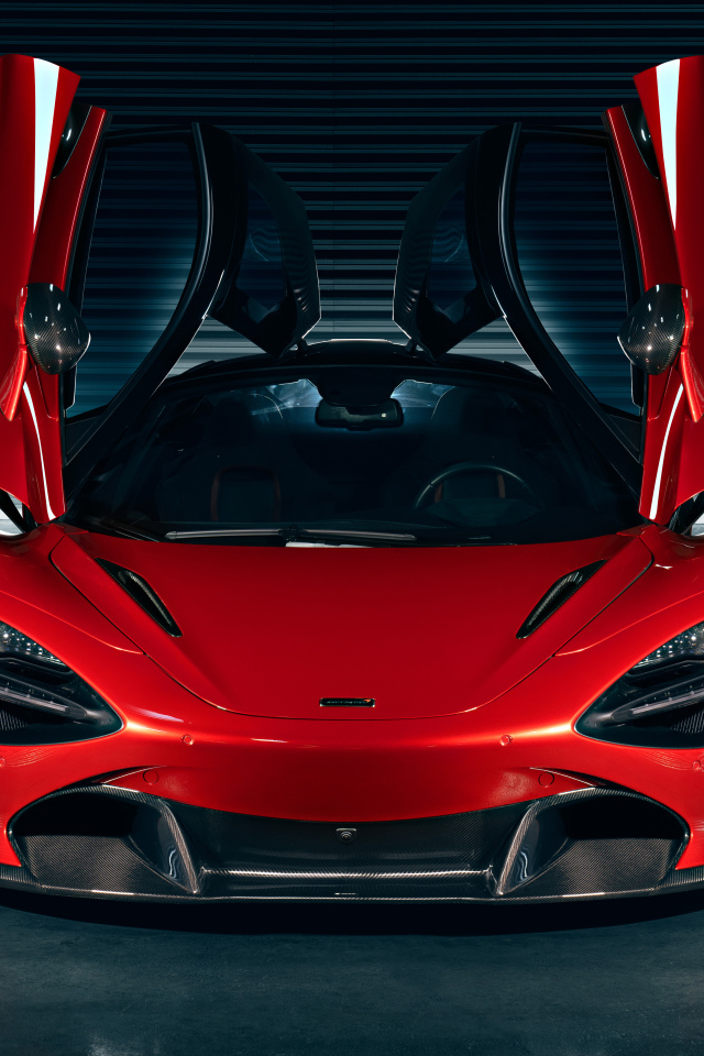 Красный автомобиль McLaren 720S с открытыми дверями в гараже