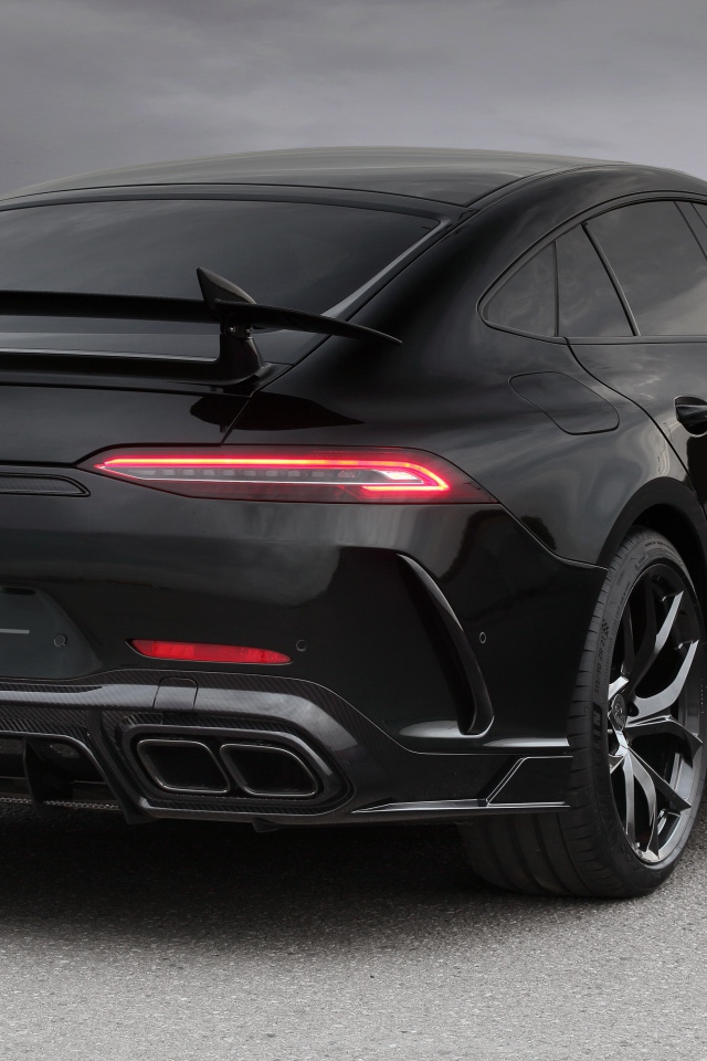 Черный автомобиль Mercedes-AMG GT 63 S 4MATIC+, 2020 года вид сзади на сером фоне