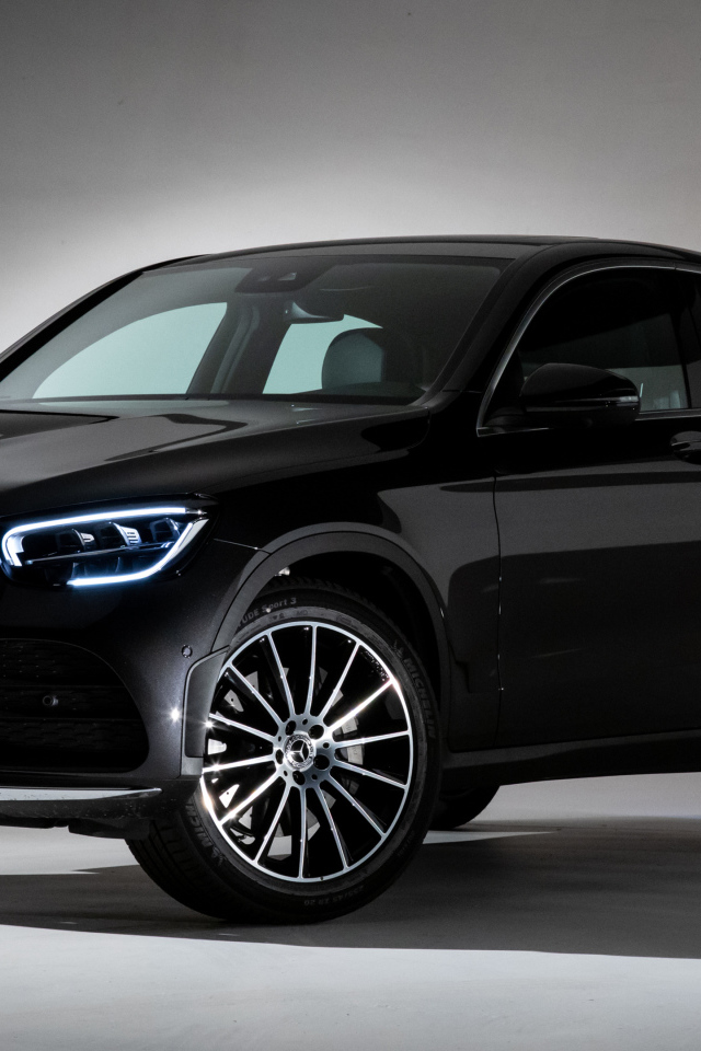 Черный стильный автомобиль Mercedes-Benz GLC 300,  2019 года на сером фоне