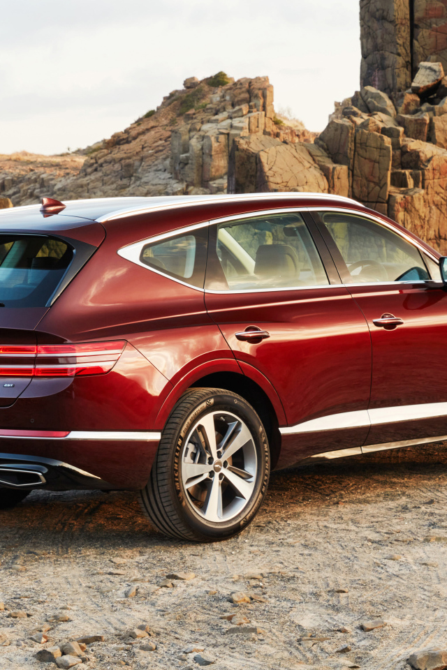 Красный автомобиль Genesis GV80 2.5T 2020 года на фоне гор