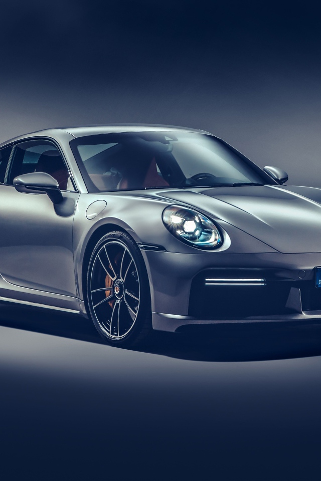 Автомобиль Porsche 911 Turbo S 2020 года на сером фоне