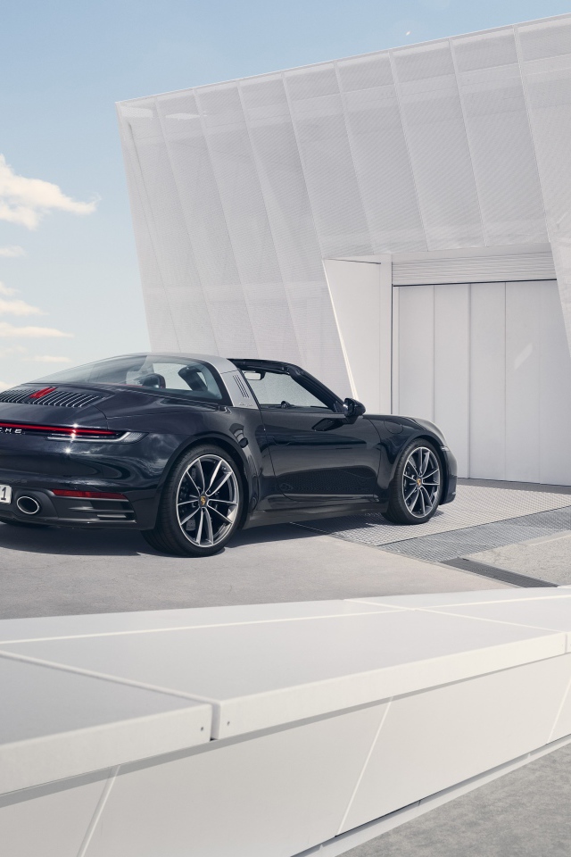 Черный автомобиль Porsche 911 Targa 4S 2020 года у гаража 