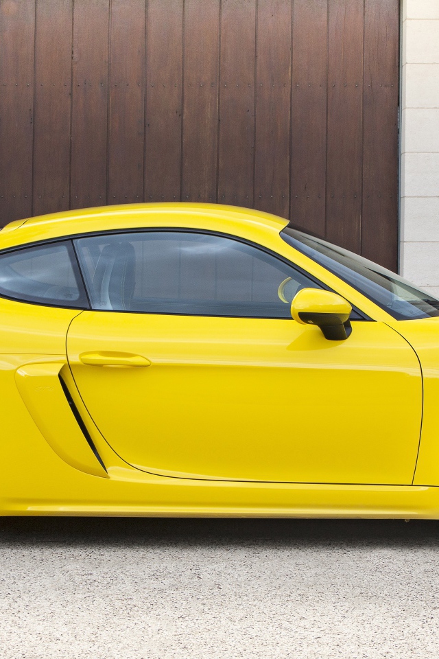 Желтый автомобиль Porsche 718 Cayman GT4 2020 года вид сбоку