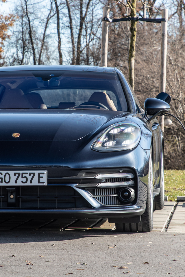 Черный автомобиль Porsche Panamera Turbo S E-Hybrid Sport Turismo 2021 года на заправке