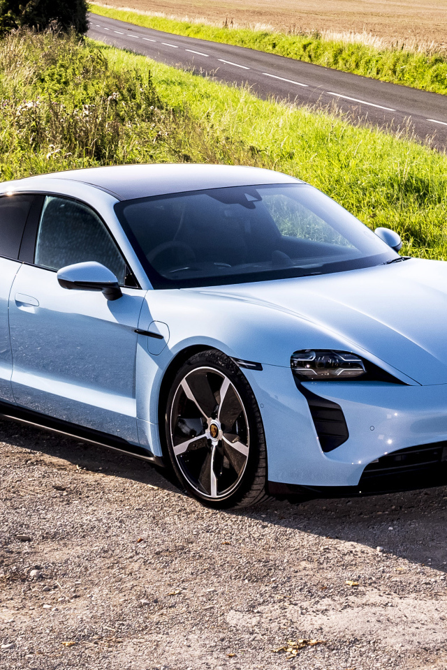 Быстрый автомобиль Porsche Taycan 4S 2021 года на фоне поля