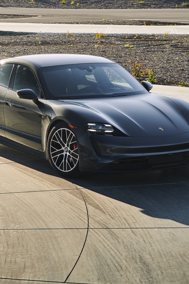 Черный автомобиль Porsche Taycan, 2020 года на дороге 