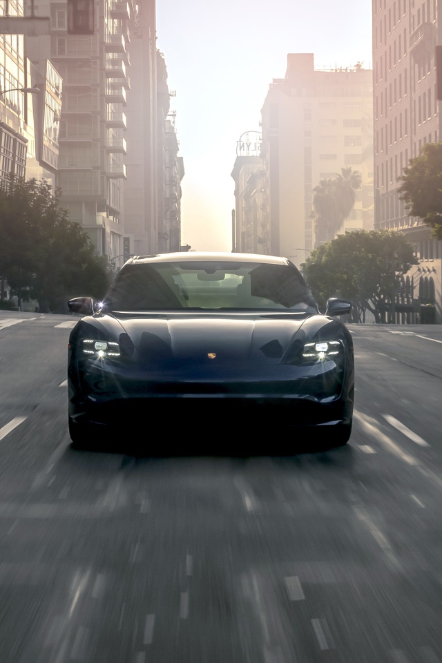 Черный стильный автомобиль  Porsche Taycan Turbo, 2020 года на дороге в городе