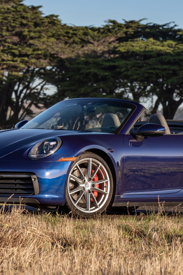 Автомобиль Porsche 911 Carrera S, 2020 года на фоне деревьев 