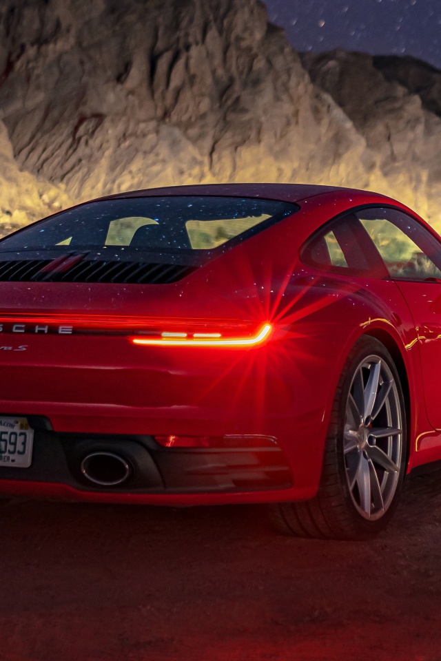 Красный автомобиль  Porsche 911 Carrera S, 2020 года в горах ночью 