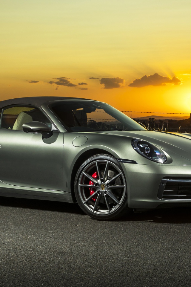 Серебристый Porsche 911 Carrera S Cabriolet 2020 года на закате 