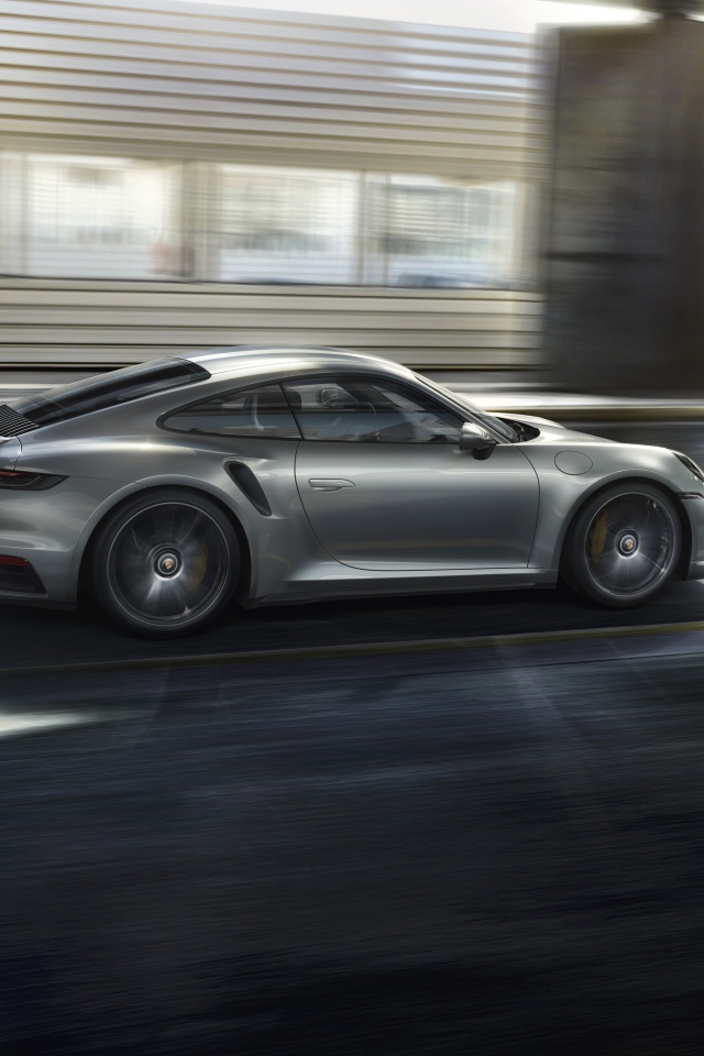 Серебристый автомобиль Porsche 911 Turbo S 2020 года на трассе 