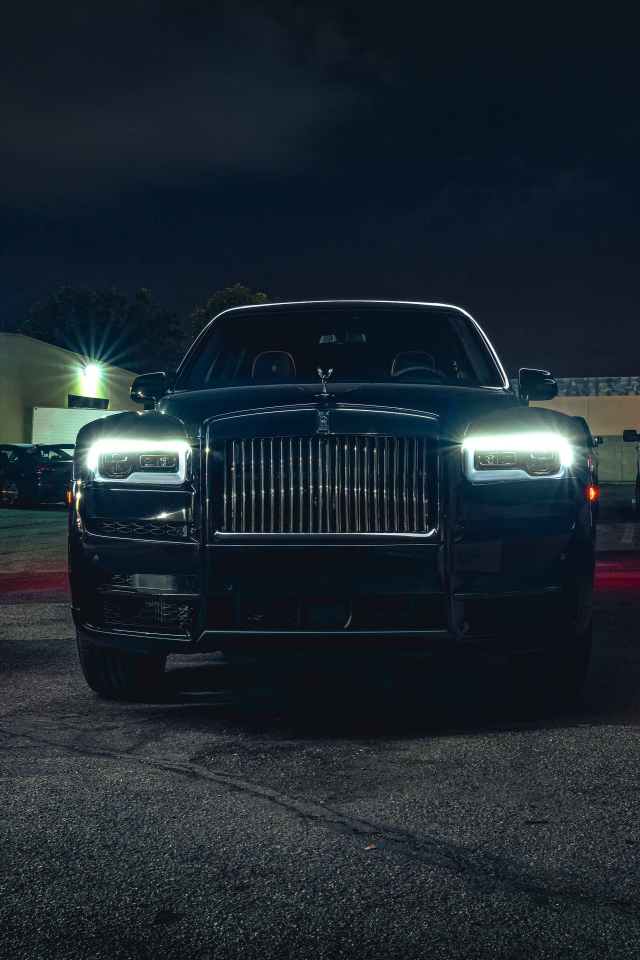 Черный дорогой автомобиль  Rolls-Royce Cullinan, 2020 года с включенными фарами