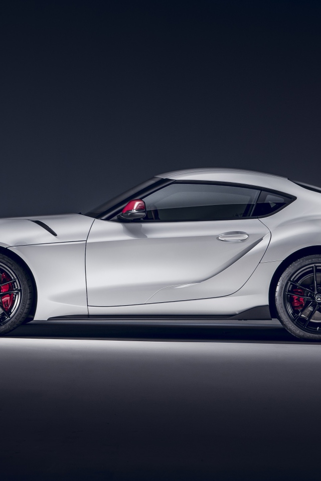 Серый автомобиль Toyota GR Supra 2L 2020 года вид сбоку на сером фоне