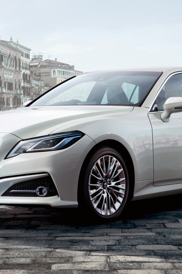 Стильный автомобиль Toyota Crown S, 2020 года на фоне здания