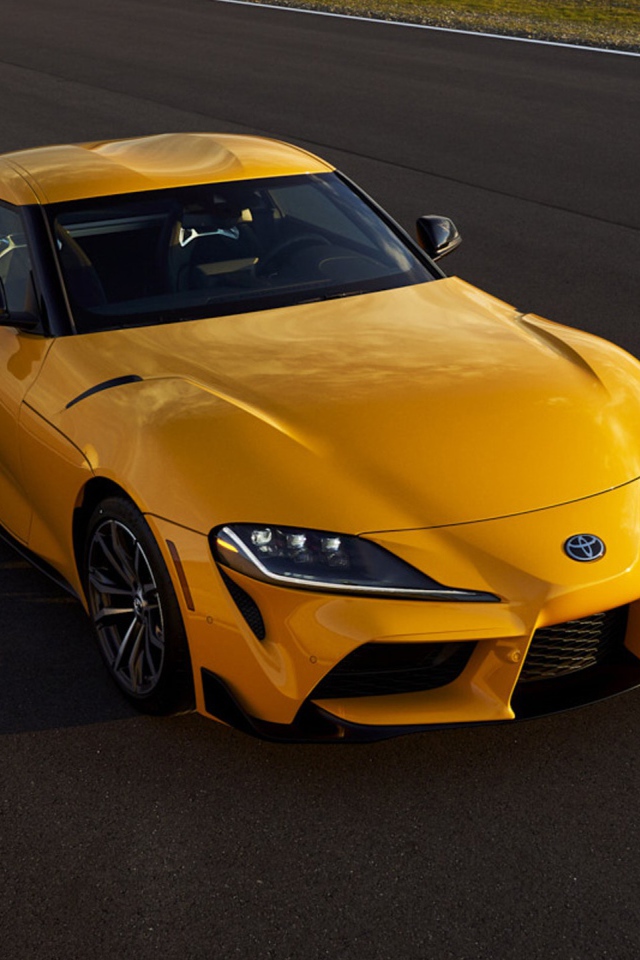 Желтый автомобиль  Toyota GR Supra, 2021 года на трассе 